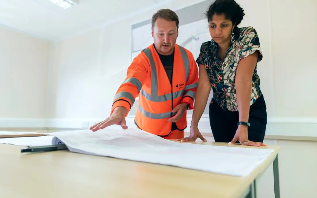 Estimator and site manager going through drawings on a table